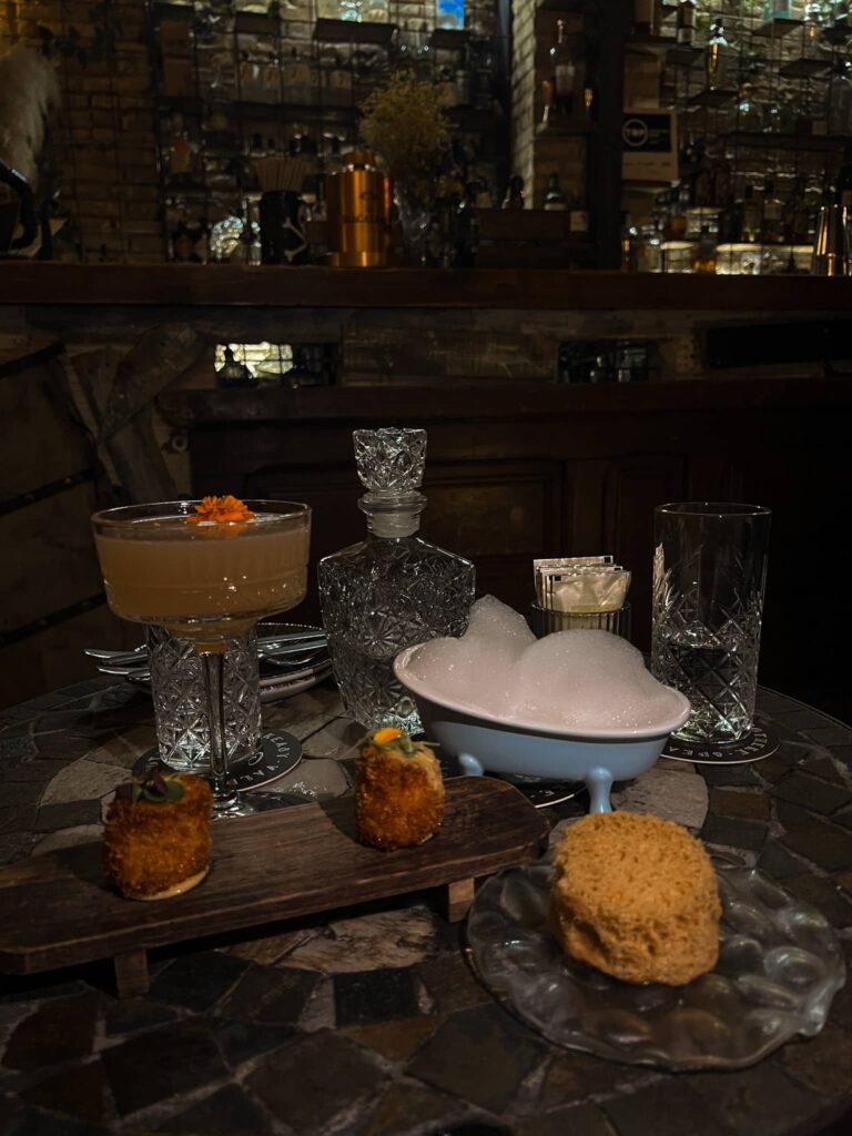 Cocktails en hapjes op tafel bij Apotheke, een speakeasy cocktailbar in Valencia.